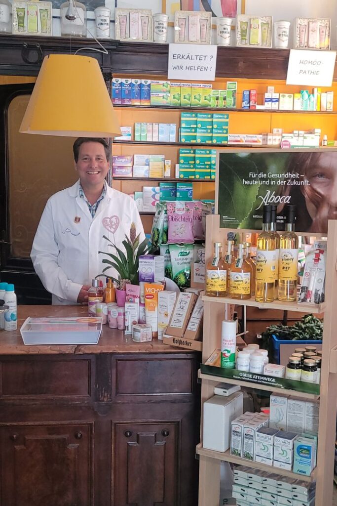 Mag. Marco Beitelberger im Verkaufsraum der St. Nikolaus Apotheke Alt-Text: Apotheker Mag. Marco Beitelberger berät im Verkaufsraum der Apotheke zu hochreinen Vitalstoffen.